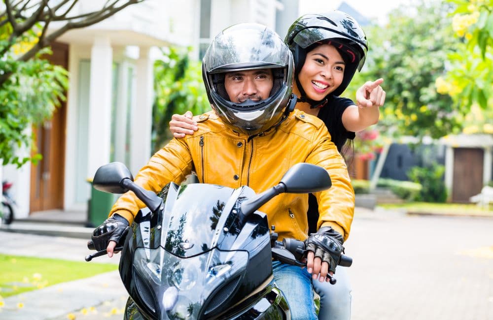 couple on motorcycle with helmets