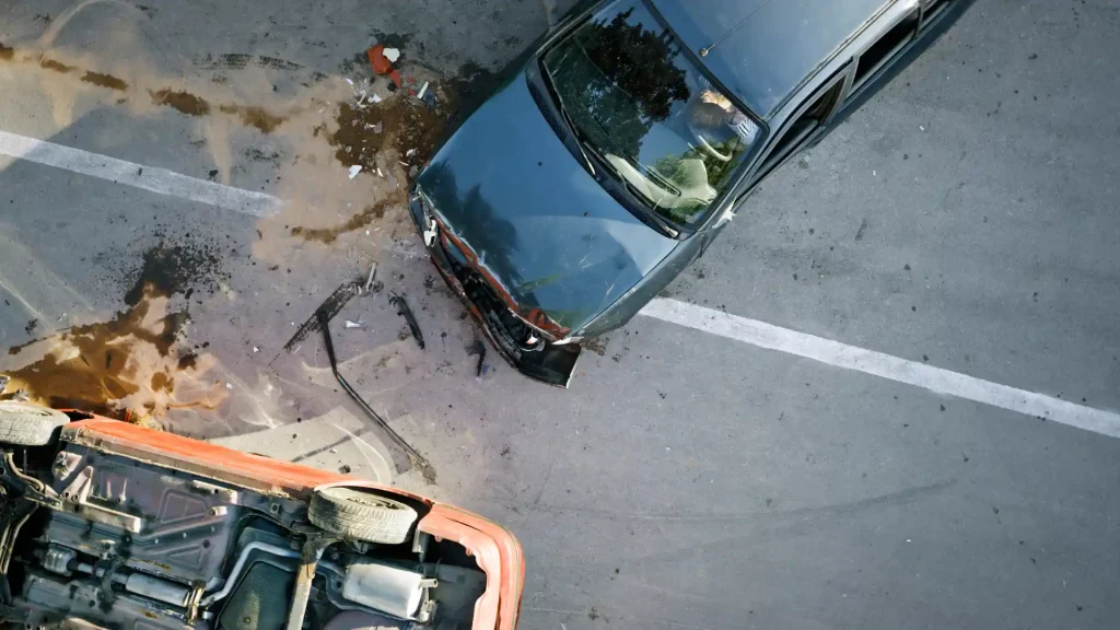 Aerial view of a car accident with visible damage and debris on the road.