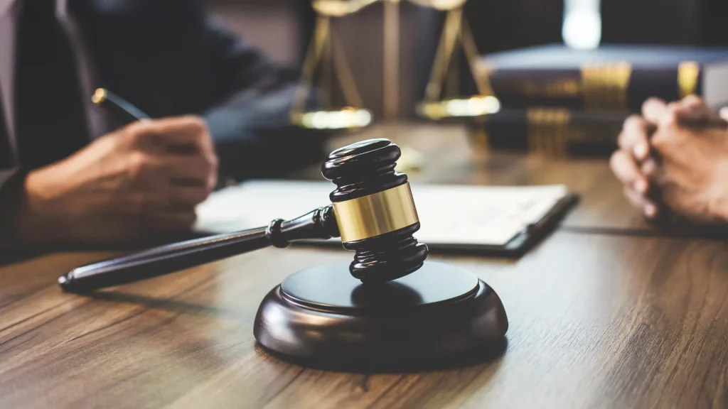 A gavel resting on a desk with legal documents in the background.